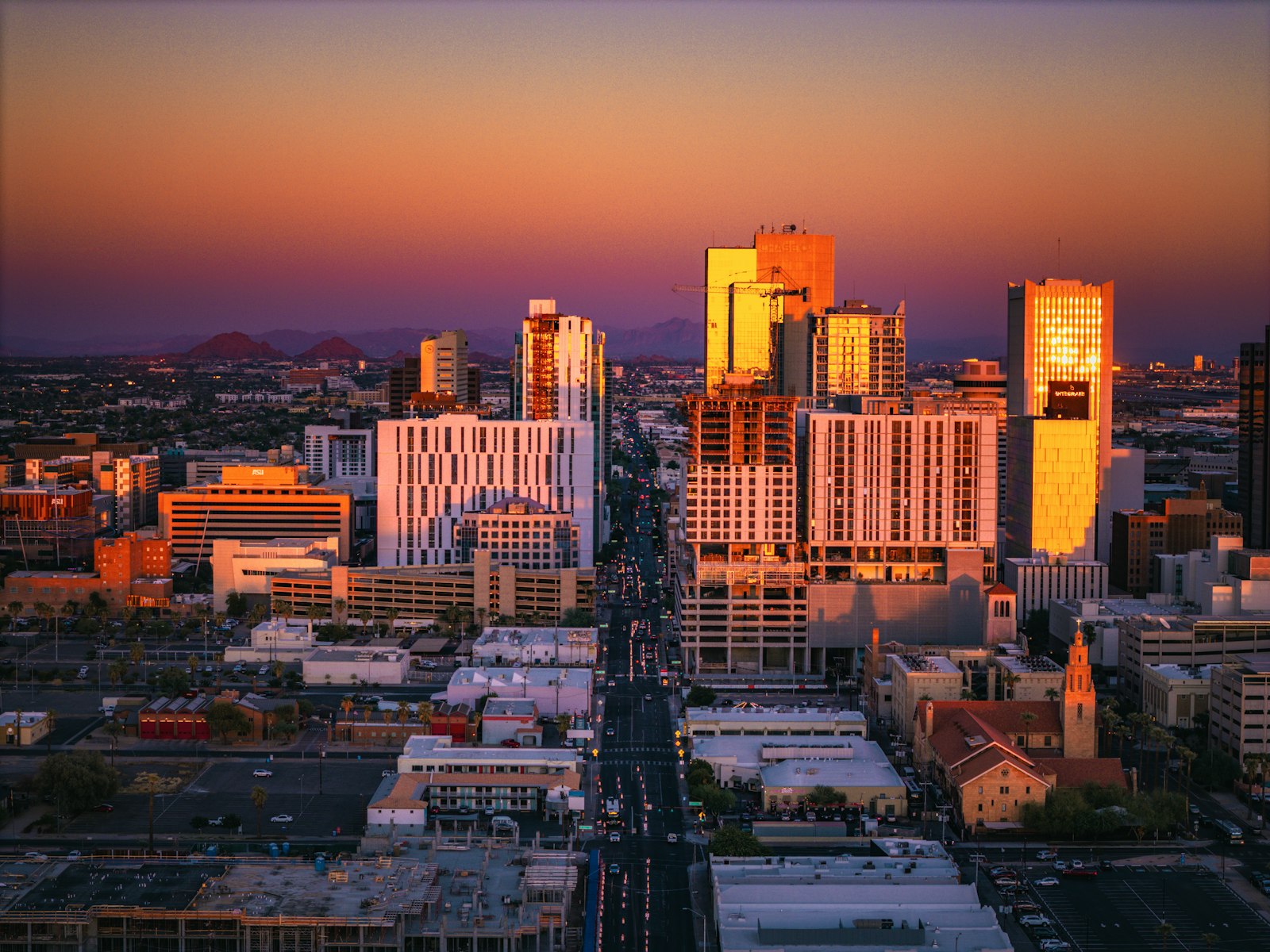Downtown Phoenix skyline at sunset with desert mountains beyond